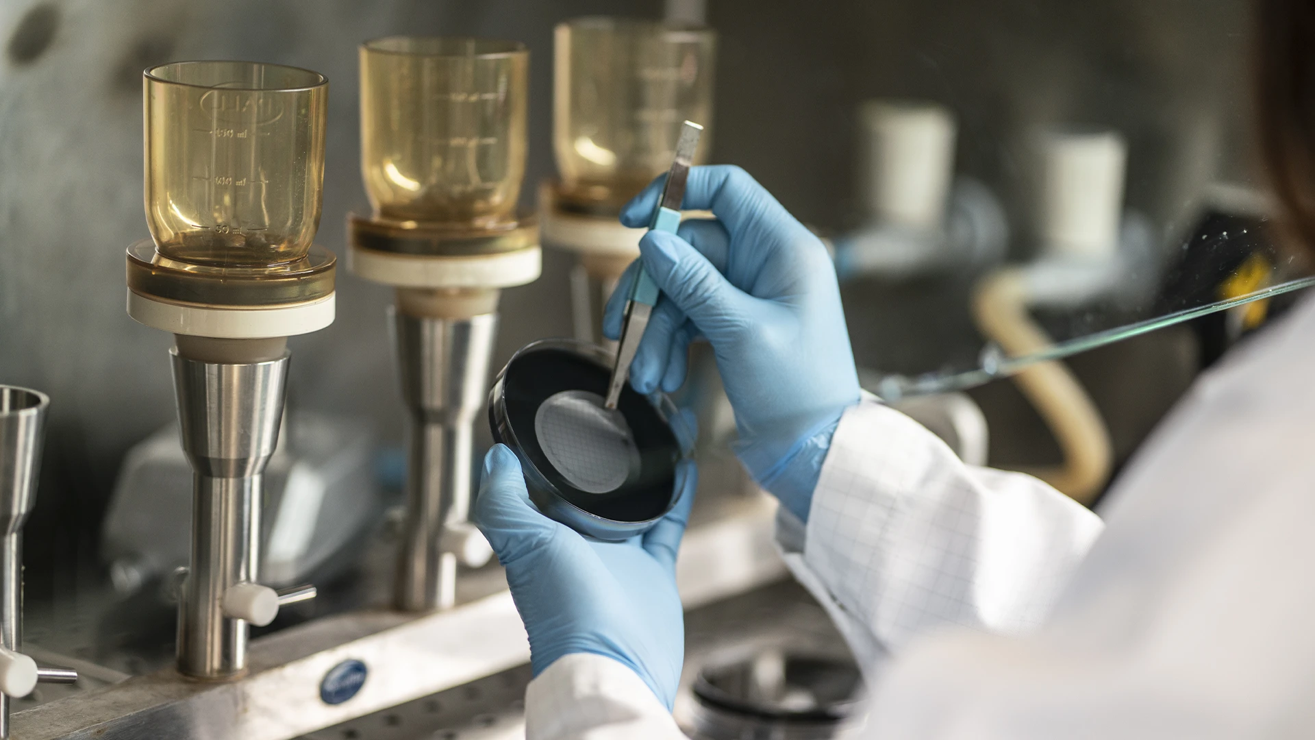 hands of a chemist with pliers for analysis in the Rivoli laboratory